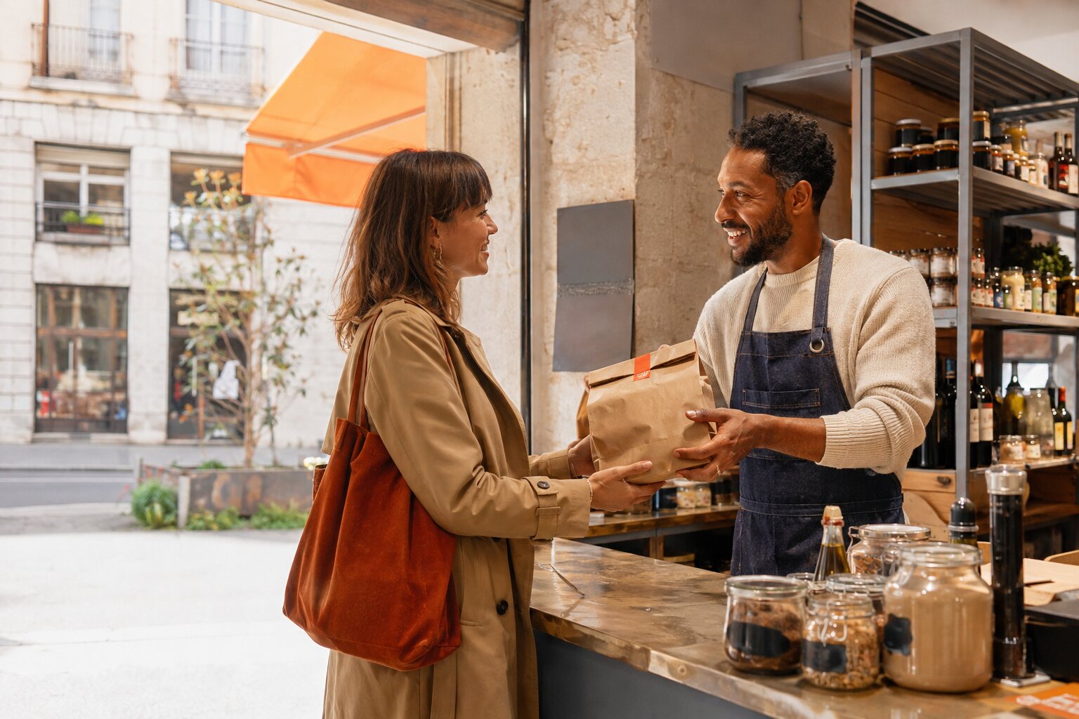 Un professionnel accueille une cliente dans son commerce